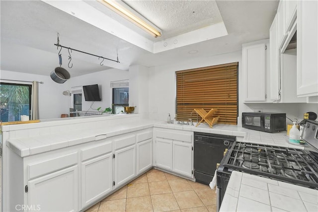 kitchen with tile counters, white cabinets, black appliances, and light tile patterned floors