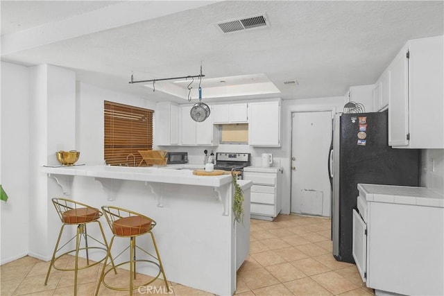 kitchen featuring kitchen peninsula, stainless steel appliances, white cabinetry, and a breakfast bar area