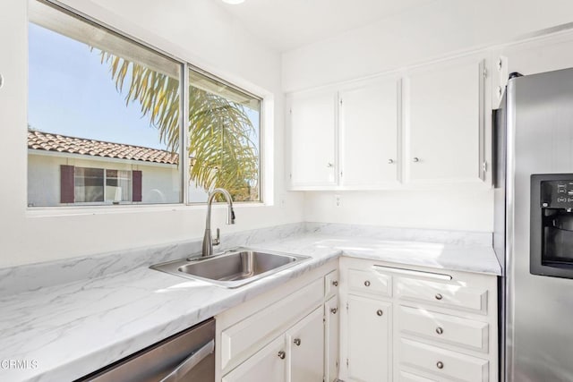 kitchen featuring appliances with stainless steel finishes, sink, and white cabinetry