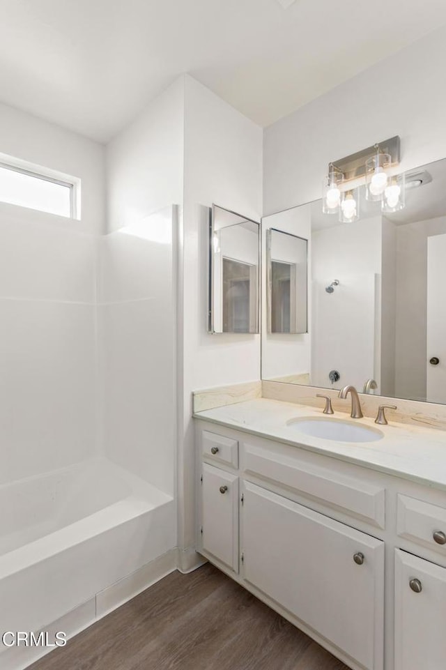 bathroom with hardwood / wood-style flooring, bathtub / shower combination, and vanity