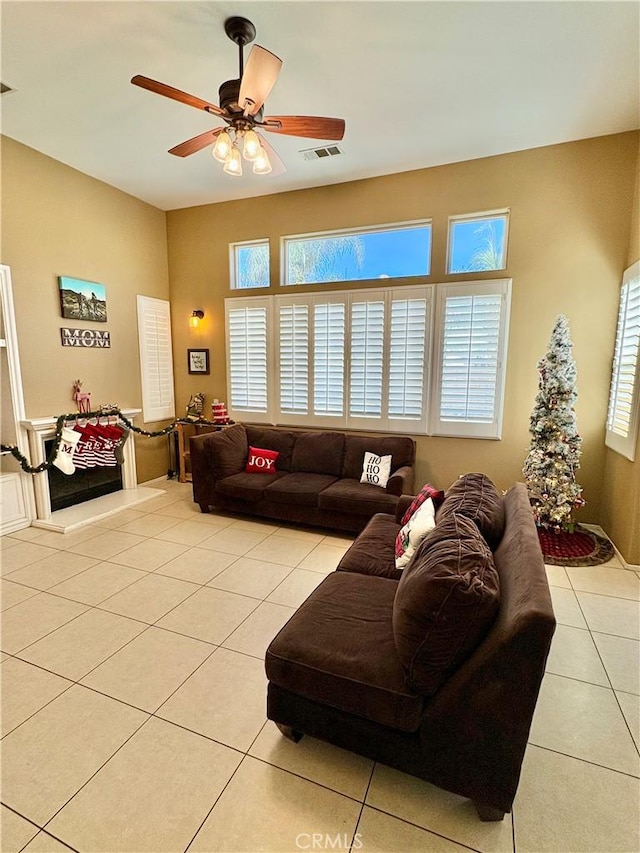 tiled living room with a wealth of natural light and ceiling fan