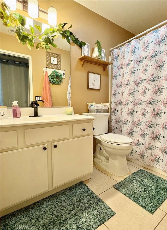 bathroom with tile patterned floors, toilet, vanity, and a shower with curtain