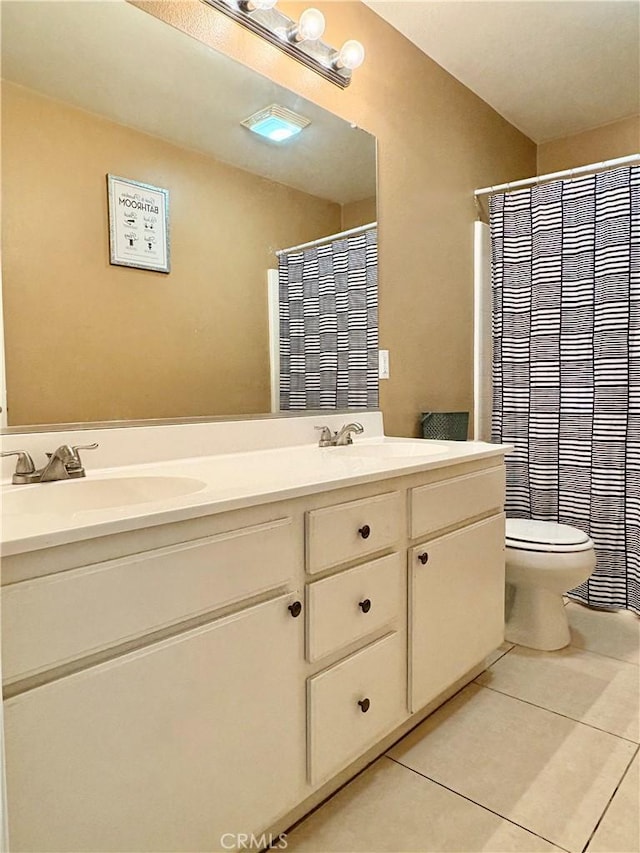 full bath with a sink, toilet, double vanity, and tile patterned floors