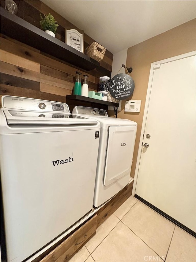 laundry area with washer and clothes dryer, laundry area, and light tile patterned flooring