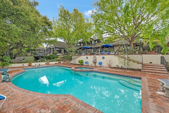 view of pool featuring an in ground hot tub