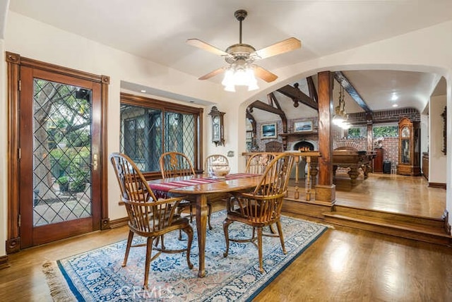 dining area featuring wood-type flooring, lofted ceiling with beams, and ceiling fan