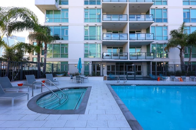 view of swimming pool featuring a patio area and a community hot tub