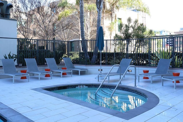 view of swimming pool featuring a patio area and a hot tub