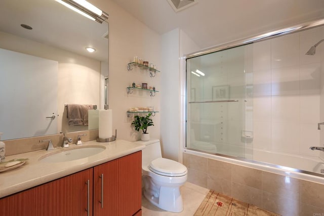 full bathroom featuring vanity, toilet, combined bath / shower with glass door, and tile patterned floors