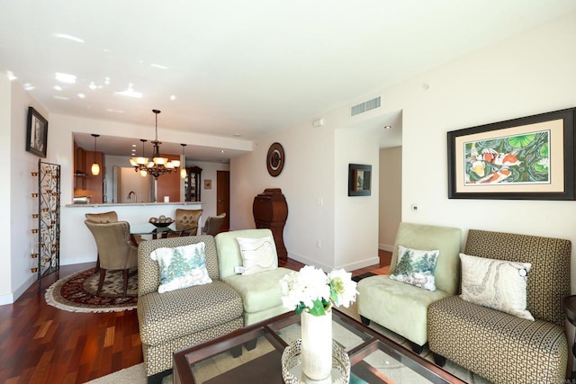 living room with an inviting chandelier and dark hardwood / wood-style flooring