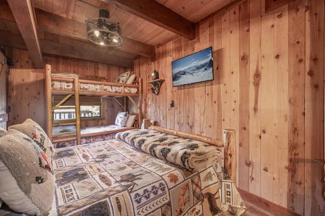 bedroom with hardwood / wood-style flooring, wood ceiling, wood walls, and beamed ceiling