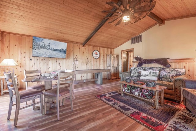 interior space featuring wood walls, hardwood / wood-style floors, wooden ceiling, ceiling fan, and vaulted ceiling with beams