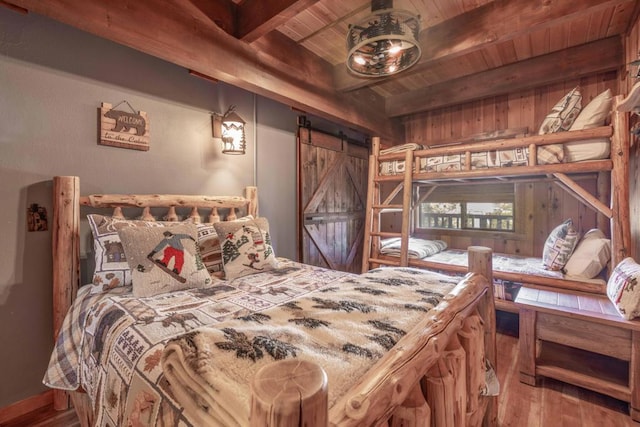 bedroom with wood ceiling, a barn door, hardwood / wood-style flooring, and beam ceiling