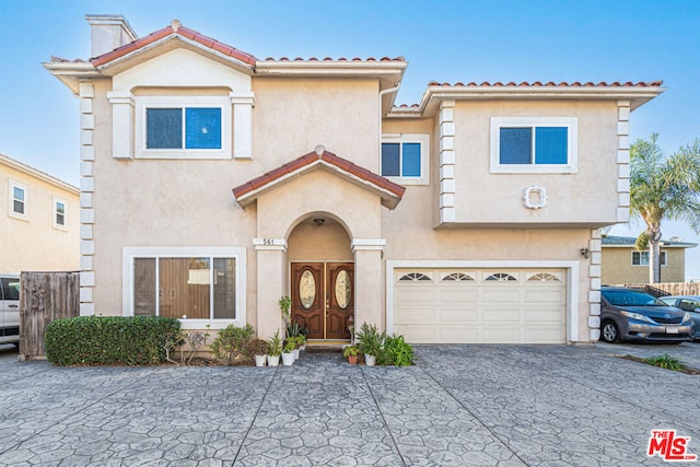 mediterranean / spanish home with a garage