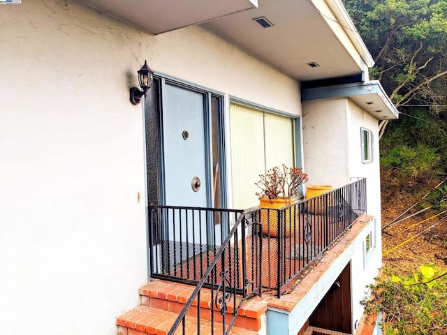 view of exterior entry featuring a balcony