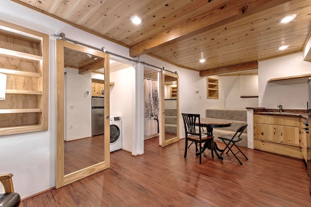 dining room featuring washer / dryer, a barn door, dark hardwood / wood-style floors, and wooden ceiling