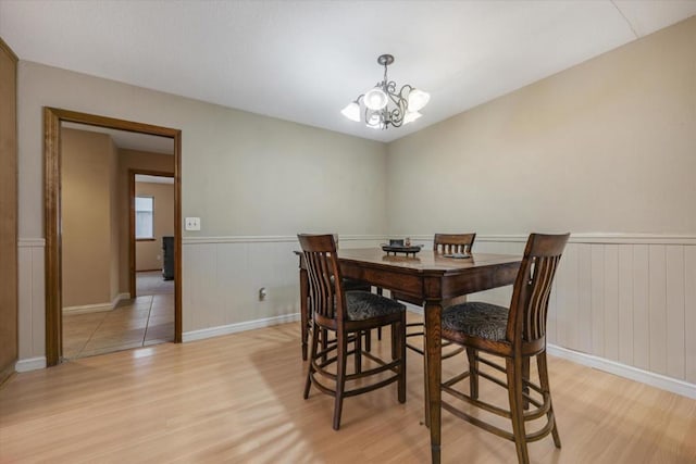 dining area featuring light wood-type flooring and a notable chandelier