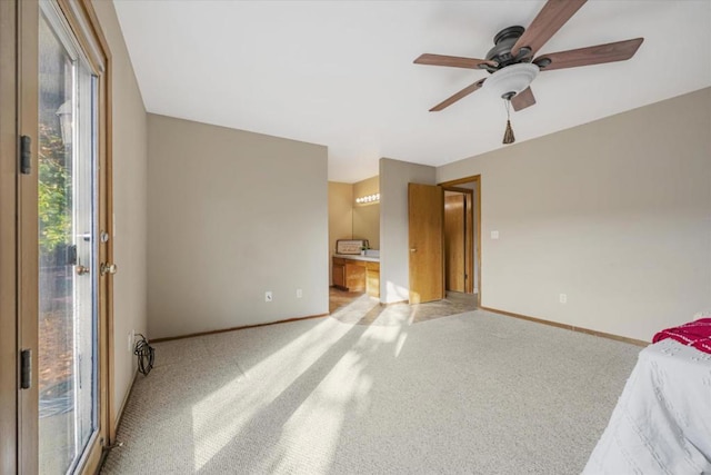 unfurnished bedroom with ceiling fan, light colored carpet, and ensuite bathroom