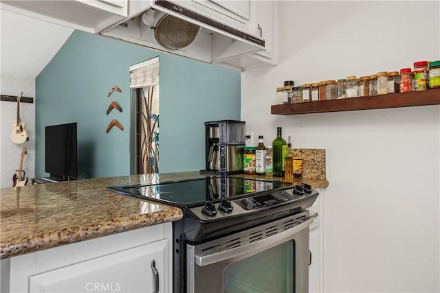 kitchen with dark stone countertops, white cabinetry, and stainless steel range with electric stovetop