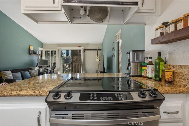 kitchen with stone counters, white cabinetry, extractor fan, and stainless steel stove