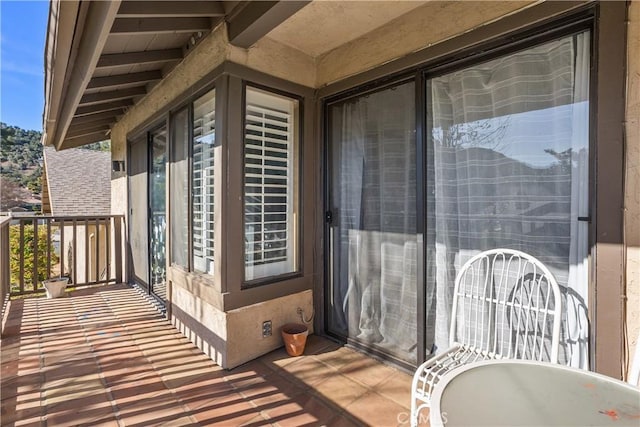 view of exterior entry featuring a balcony