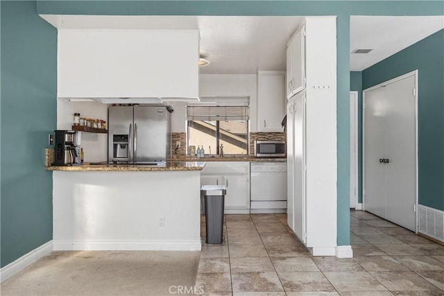 kitchen with white cabinets, decorative backsplash, stainless steel appliances, and kitchen peninsula