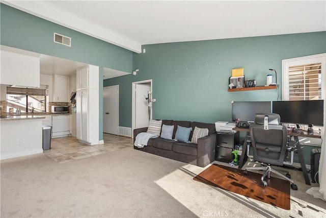 carpeted home office featuring lofted ceiling