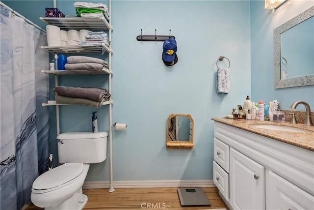 bathroom with toilet, vanity, and hardwood / wood-style flooring