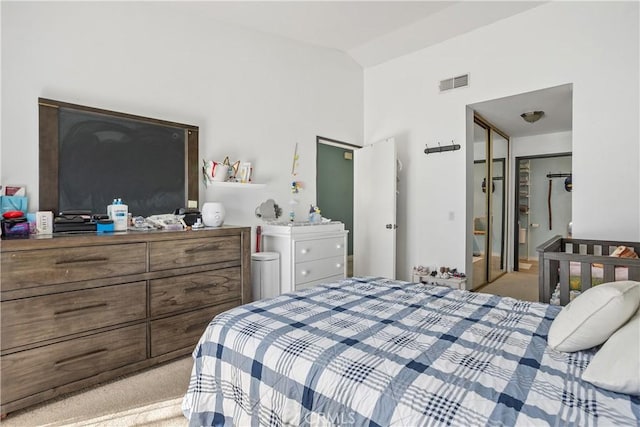 carpeted bedroom with vaulted ceiling and a closet