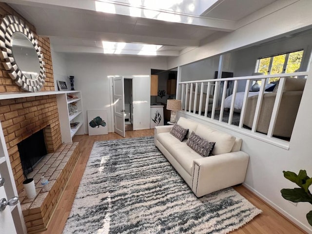 living room featuring beam ceiling, a fireplace, and hardwood / wood-style floors