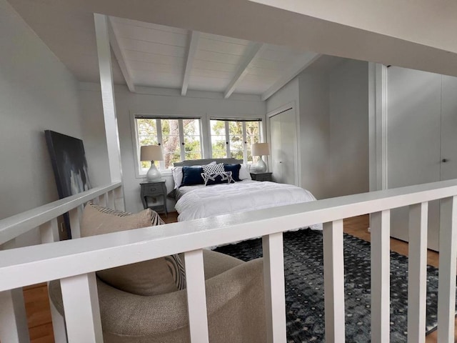 bedroom with wood-type flooring and lofted ceiling with beams