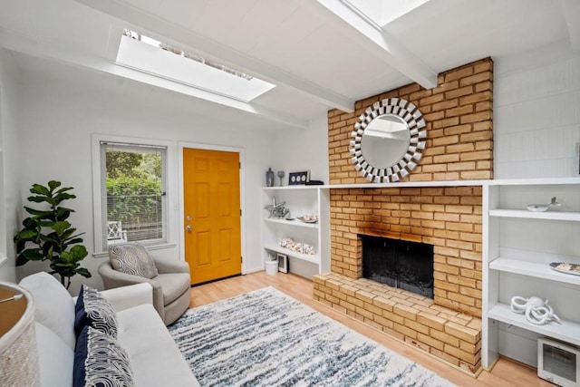 living room featuring a brick fireplace, light hardwood / wood-style flooring, and beam ceiling