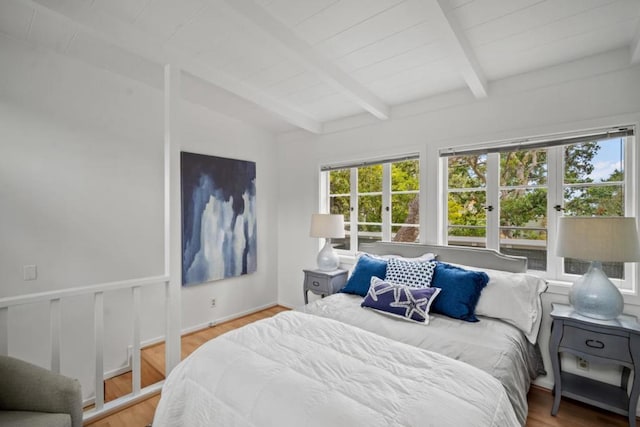 bedroom featuring vaulted ceiling with beams and hardwood / wood-style flooring