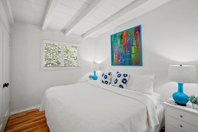 bedroom featuring beam ceiling and wood-type flooring