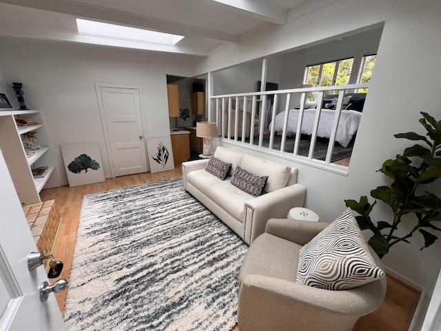 living room with beamed ceiling and wood-type flooring