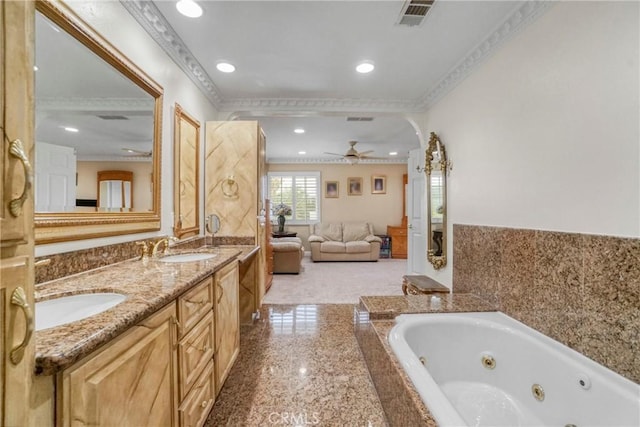 bathroom featuring ceiling fan, a washtub, vanity, and ornamental molding