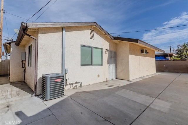 rear view of house with cooling unit and a patio