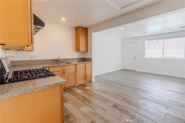 kitchen featuring stove, exhaust hood, sink, light brown cabinets, and light hardwood / wood-style floors