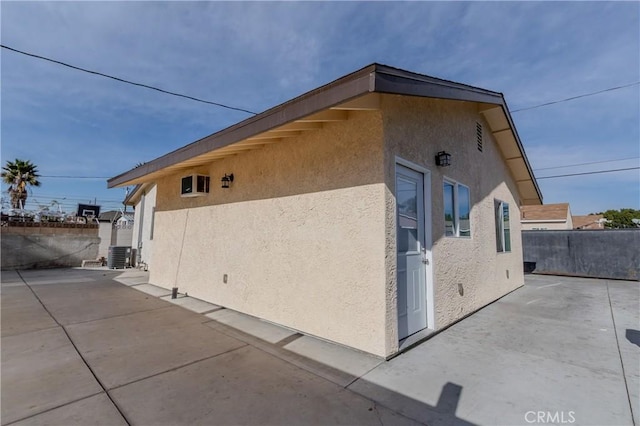 view of side of home featuring central air condition unit and a patio area