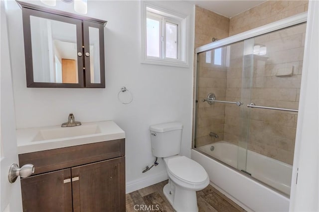 full bathroom with hardwood / wood-style floors, vanity, enclosed tub / shower combo, and toilet