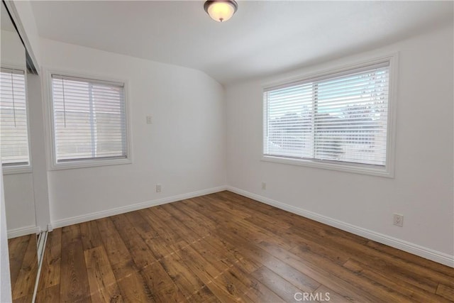 empty room with a healthy amount of sunlight and dark hardwood / wood-style floors