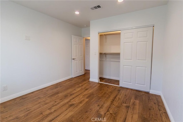 unfurnished bedroom featuring a closet and hardwood / wood-style flooring