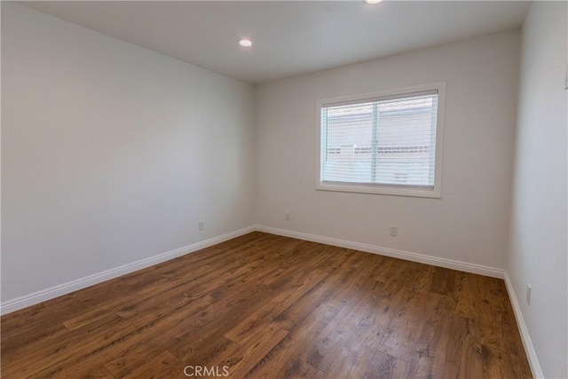 spare room with dark wood-type flooring