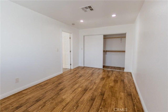 unfurnished bedroom featuring wood-type flooring and a closet