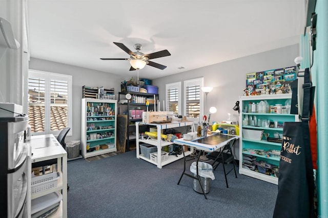 carpeted home office featuring ceiling fan