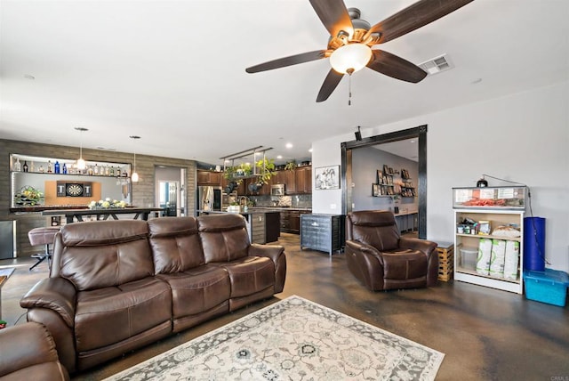 living room with ceiling fan and bar area