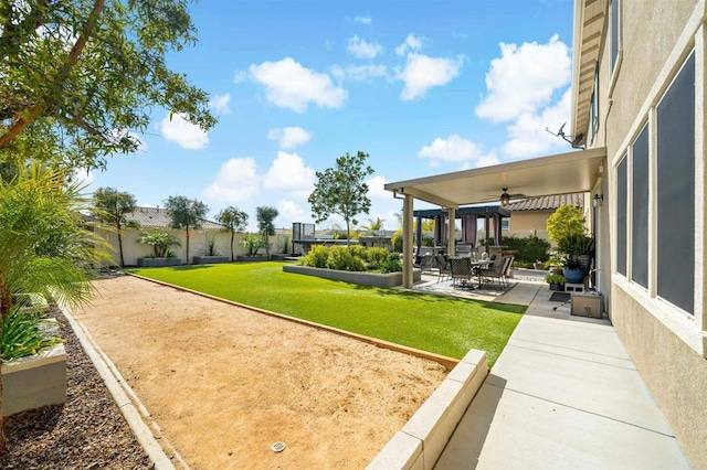 view of yard with ceiling fan and a patio