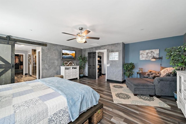 bedroom featuring a spacious closet, a closet, and a barn door