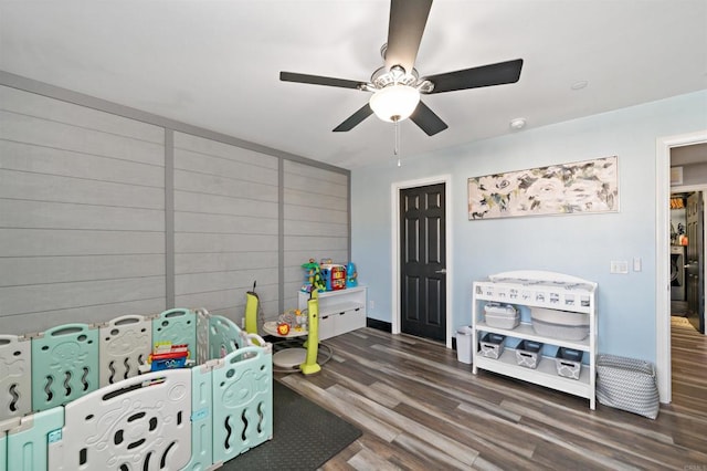 game room with dark wood-type flooring and ceiling fan