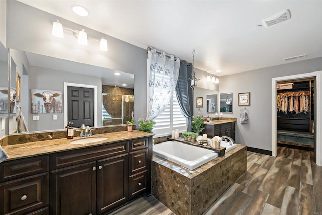 bathroom with separate shower and tub, vanity, and wood-type flooring